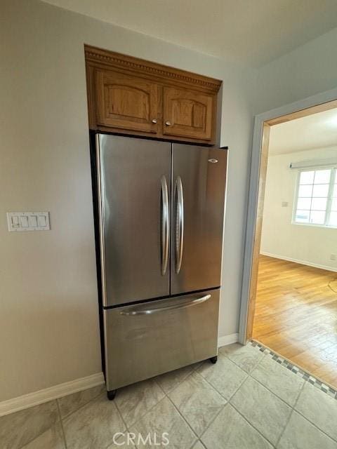 kitchen with stainless steel fridge and light hardwood / wood-style flooring