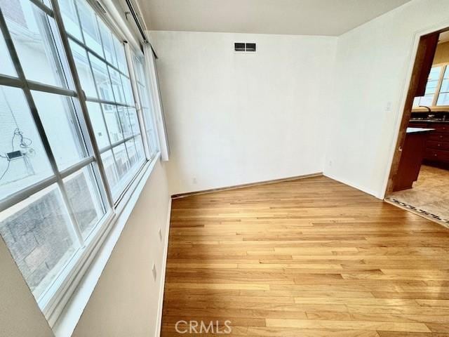 spare room with a healthy amount of sunlight and light hardwood / wood-style flooring