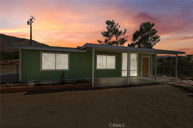 back house at dusk featuring a patio