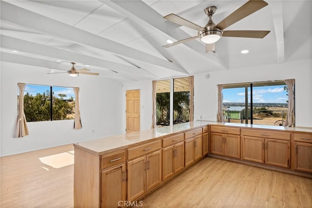 kitchen featuring vaulted ceiling with beams, light hardwood / wood-style flooring, kitchen peninsula, and ceiling fan