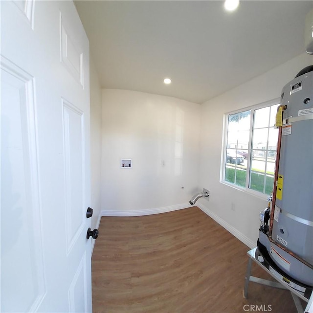 laundry area with hardwood / wood-style flooring and gas water heater