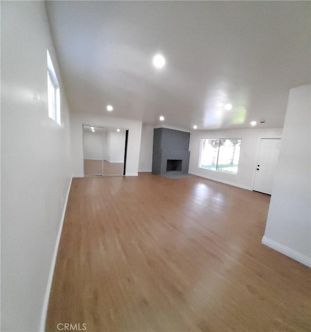 unfurnished living room with a fireplace and wood-type flooring