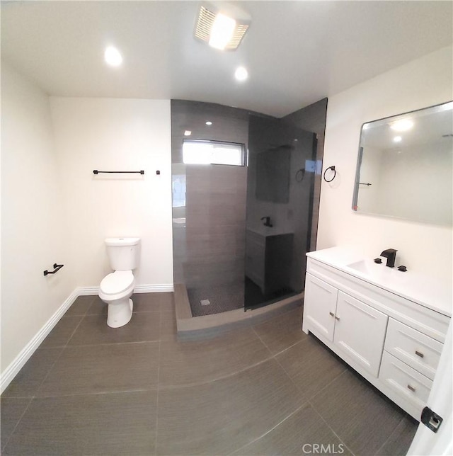 bathroom with toilet, vanity, tile patterned floors, and a tile shower