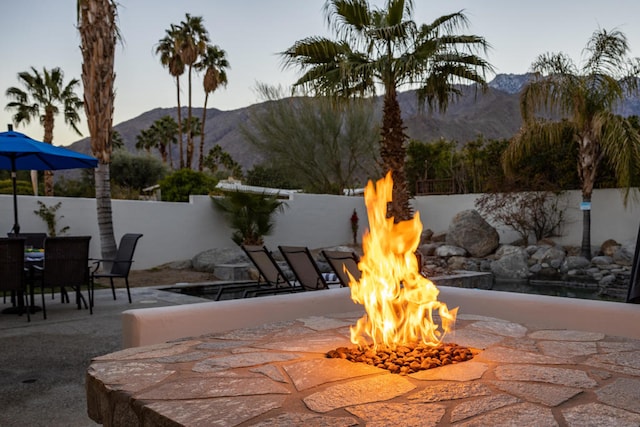 view of patio / terrace featuring an outdoor fire pit and a mountain view