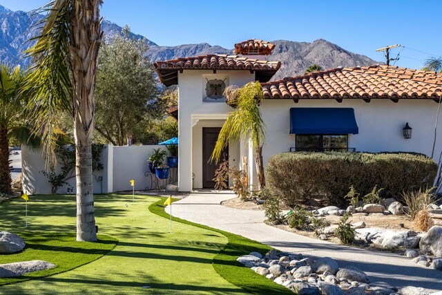 mediterranean / spanish home featuring a front lawn and a mountain view