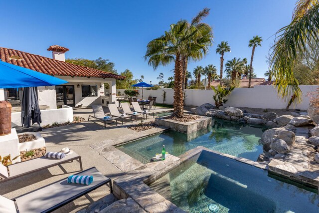 view of swimming pool with a patio and an in ground hot tub