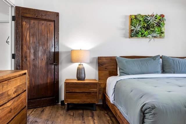 bedroom with dark hardwood / wood-style floors