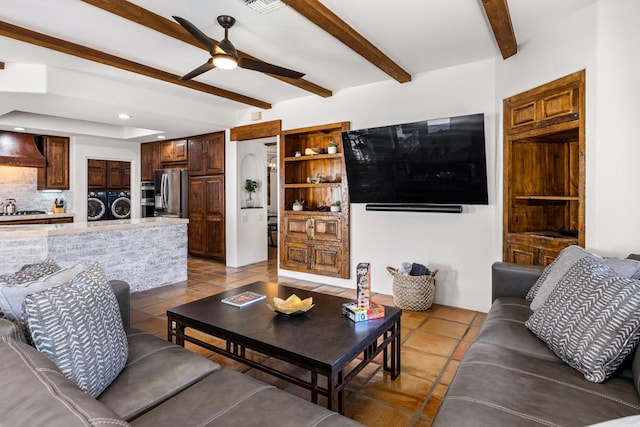 living room with beam ceiling, ceiling fan, washer and clothes dryer, and light tile patterned floors