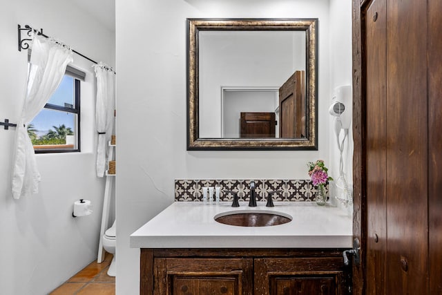 bathroom featuring tile patterned flooring, vanity, and toilet