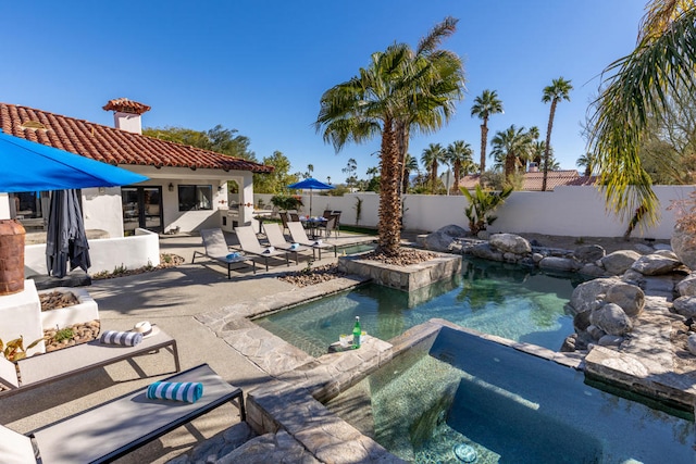 view of swimming pool featuring an in ground hot tub and a patio area