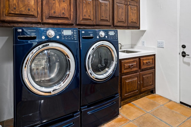 laundry area featuring light tile patterned floors, cabinets, sink, and washer and dryer