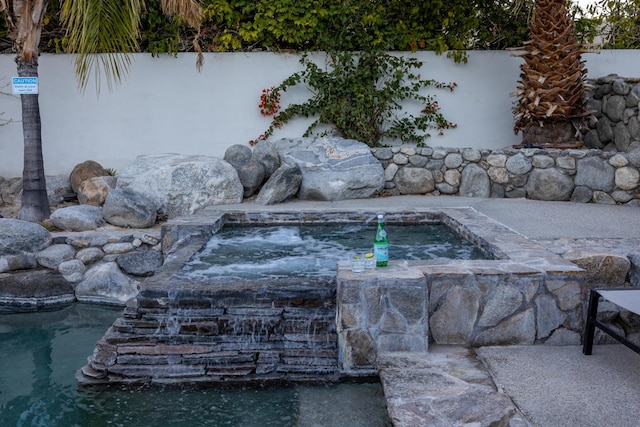 view of pool with a hot tub