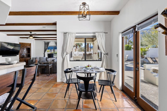 tiled dining area featuring ceiling fan with notable chandelier, a healthy amount of sunlight, french doors, and beamed ceiling