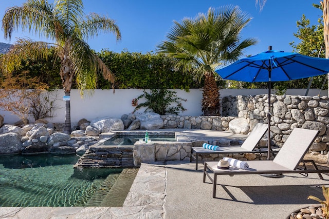 view of swimming pool with an in ground hot tub