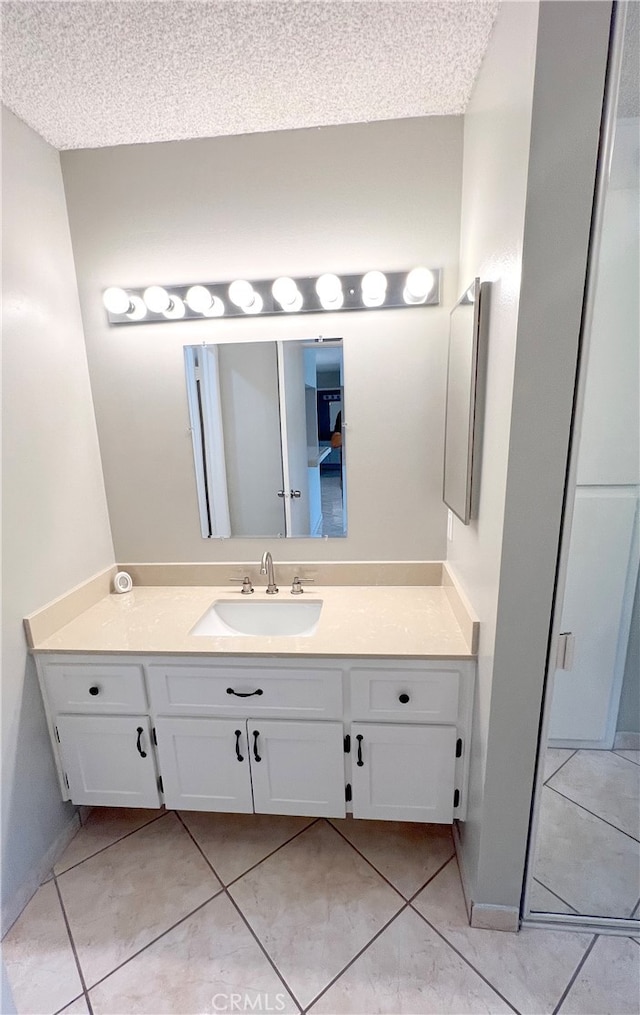 bathroom featuring tile patterned floors, vanity, and a textured ceiling