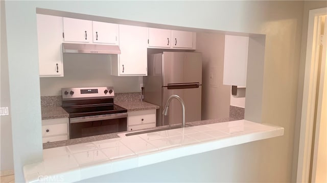 kitchen with tile countertops, white cabinets, appliances with stainless steel finishes, and sink