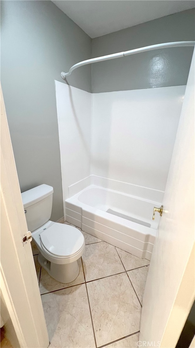 bathroom featuring tile patterned flooring, bathtub / shower combination, and toilet