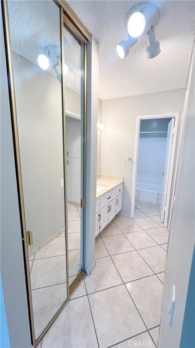 bathroom featuring tile patterned flooring, vanity, and a textured ceiling