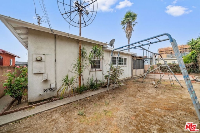 rear view of property with a playground