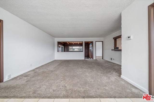 unfurnished living room with light tile patterned floors and a textured ceiling