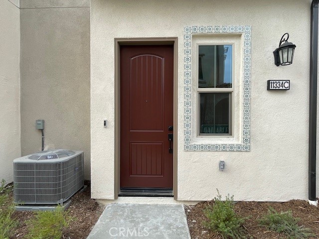 view of exterior entry featuring central air condition unit