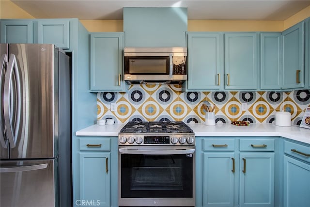 kitchen with appliances with stainless steel finishes, decorative backsplash, and blue cabinetry