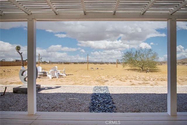 view of yard with a rural view, a pergola, and a patio area