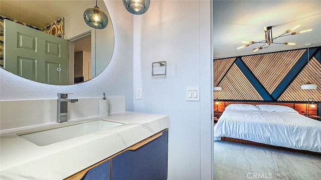 bedroom featuring an inviting chandelier and sink