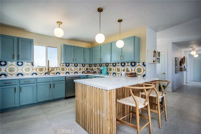 kitchen featuring stainless steel dishwasher, kitchen peninsula, a breakfast bar area, decorative light fixtures, and backsplash