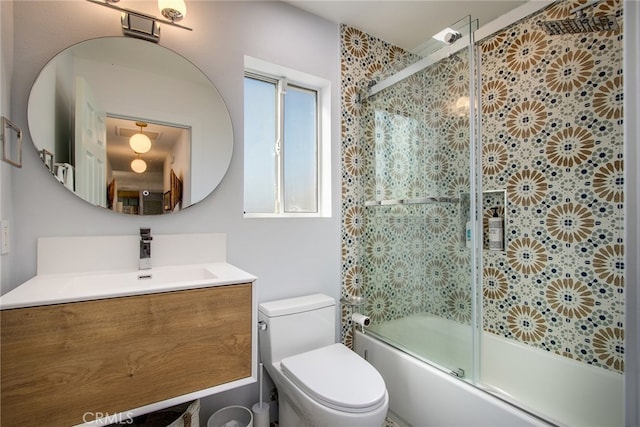 full bathroom featuring vanity, combined bath / shower with glass door, and toilet