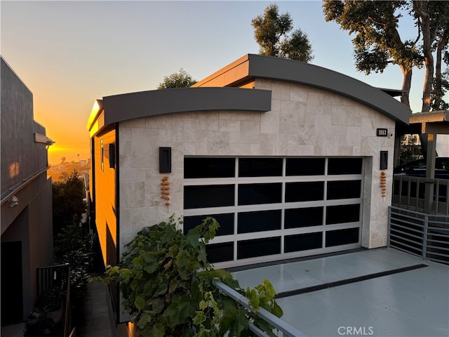 view of garage at dusk