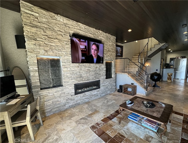 living room featuring a stone fireplace and wooden ceiling