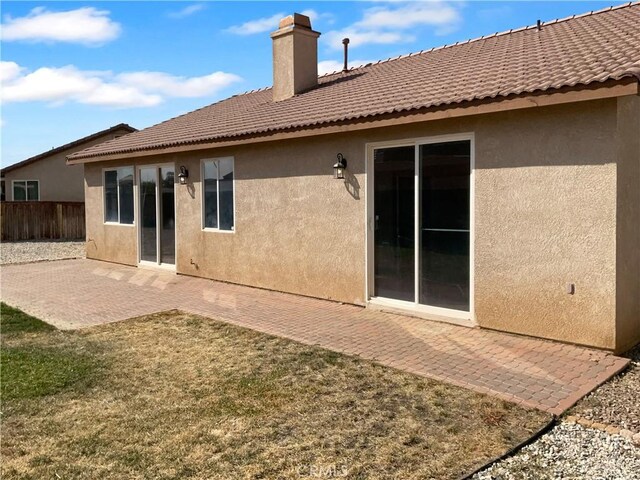 rear view of house featuring a patio and a lawn