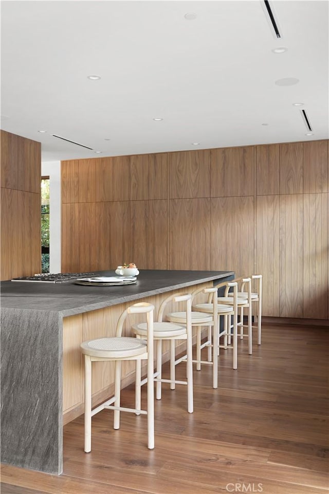 unfurnished dining area with dark hardwood / wood-style flooring and wooden walls