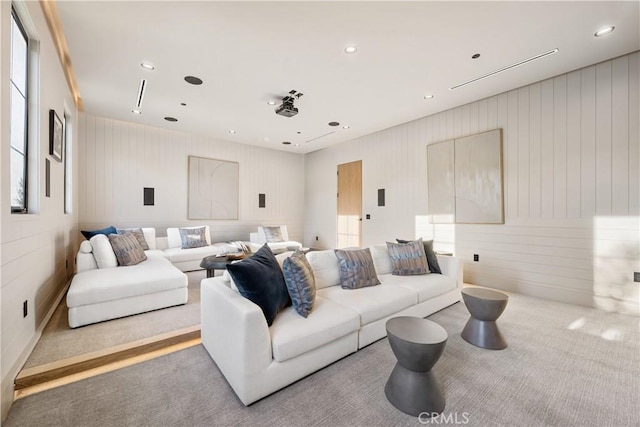 living room with wood walls and light colored carpet