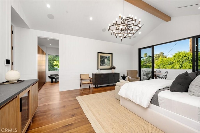 bedroom with multiple windows, wood-type flooring, a notable chandelier, and vaulted ceiling with beams