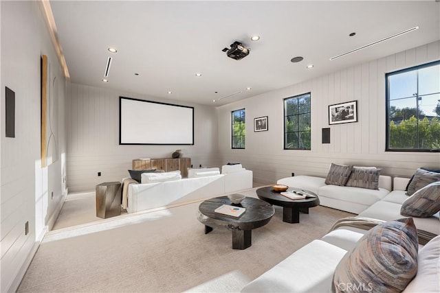 carpeted cinema with plenty of natural light and wood walls