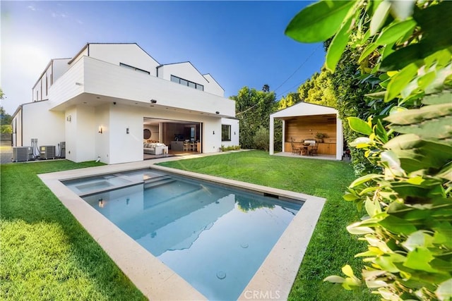 back of house featuring a lawn, central air condition unit, a patio, and an outdoor hangout area