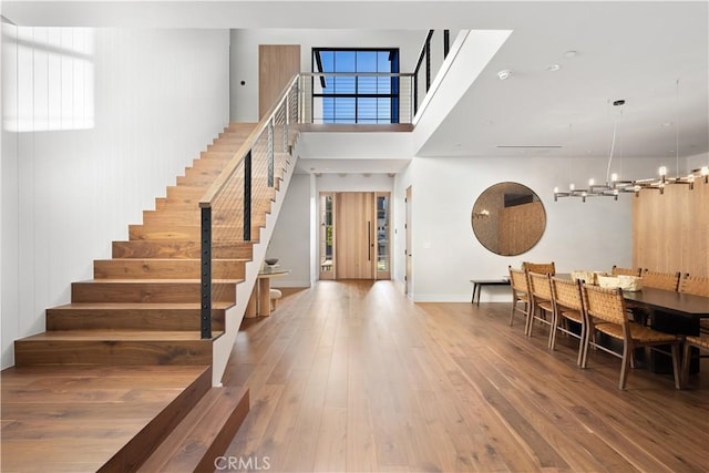 entrance foyer with hardwood / wood-style floors, a wealth of natural light, and a notable chandelier