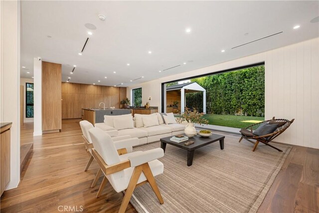 living room with light hardwood / wood-style flooring and wooden walls