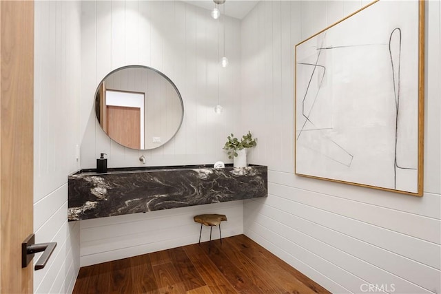 bathroom featuring hardwood / wood-style flooring and wood walls