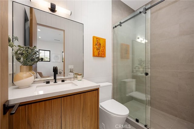 bathroom featuring walk in shower, vanity, and toilet