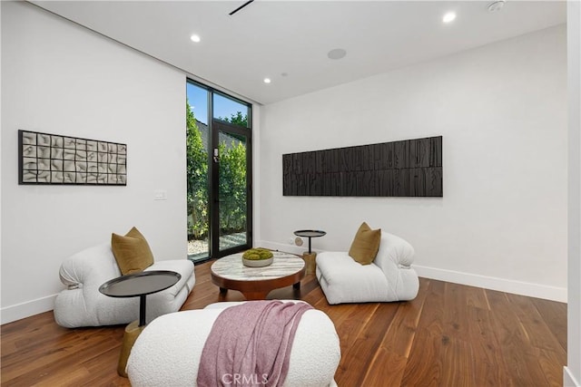 sitting room with wood-type flooring and a wall of windows