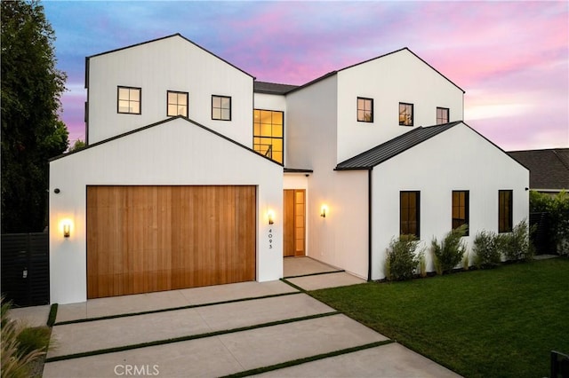 modern inspired farmhouse featuring a lawn and a garage