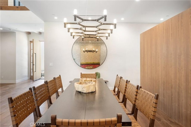 dining area with light hardwood / wood-style flooring and a chandelier