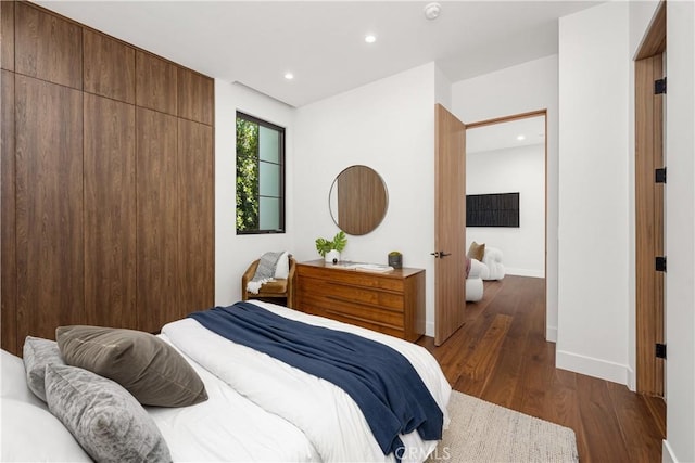 bedroom with dark hardwood / wood-style floors and a closet