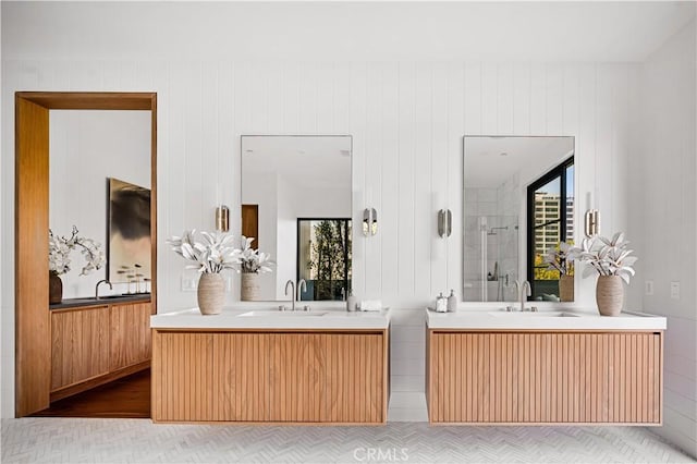 bathroom featuring wood walls, a shower with door, and vanity