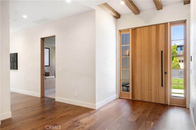 foyer with plenty of natural light, dark hardwood / wood-style floors, and beam ceiling