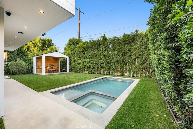 view of pool featuring an in ground hot tub, a yard, a patio, and an outdoor structure