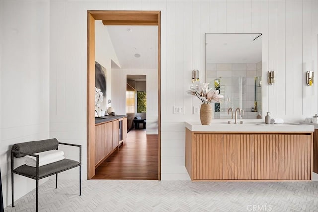 bathroom featuring vanity, vaulted ceiling, and hardwood / wood-style flooring